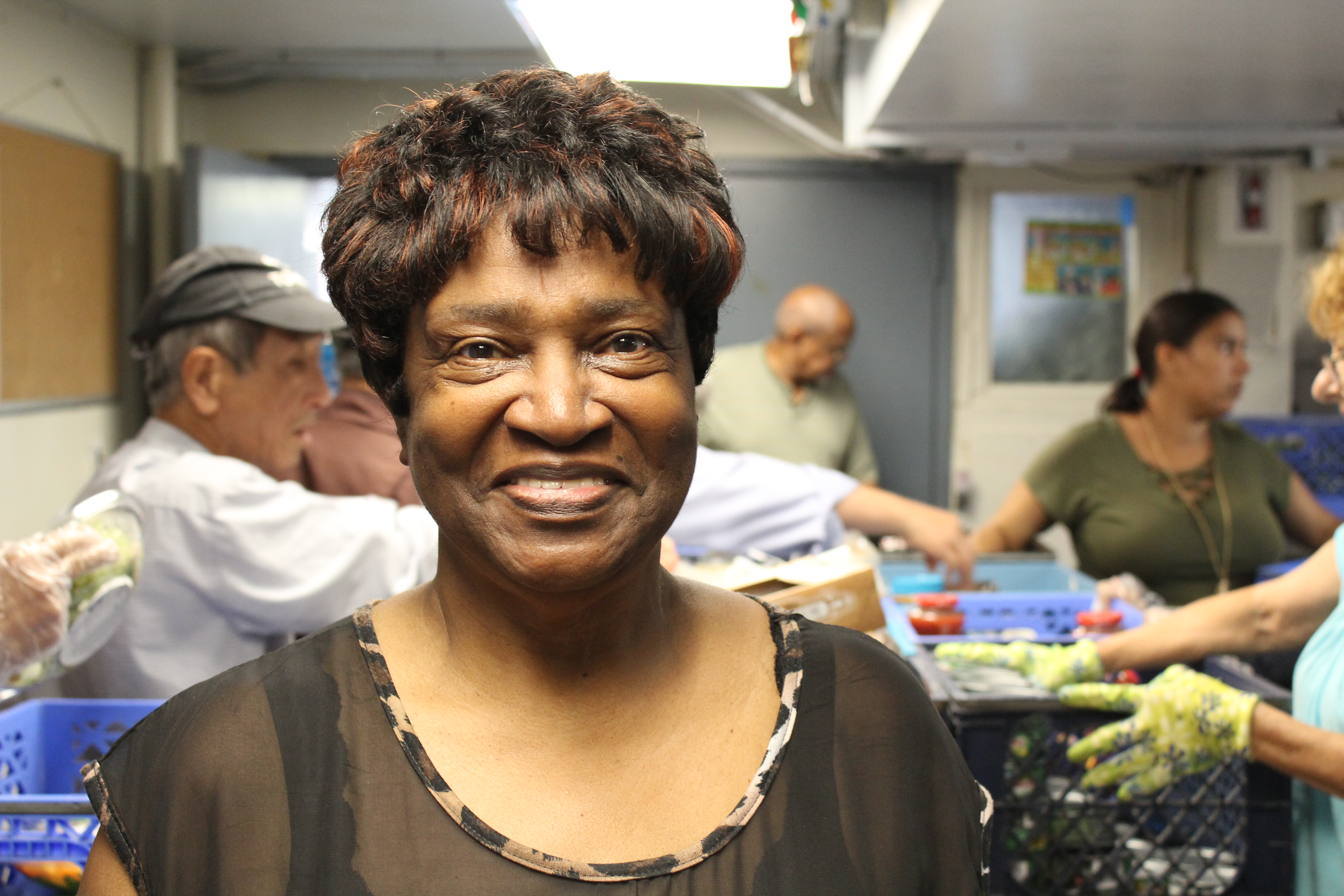 Smiling woman looks into camera during food bank distribution